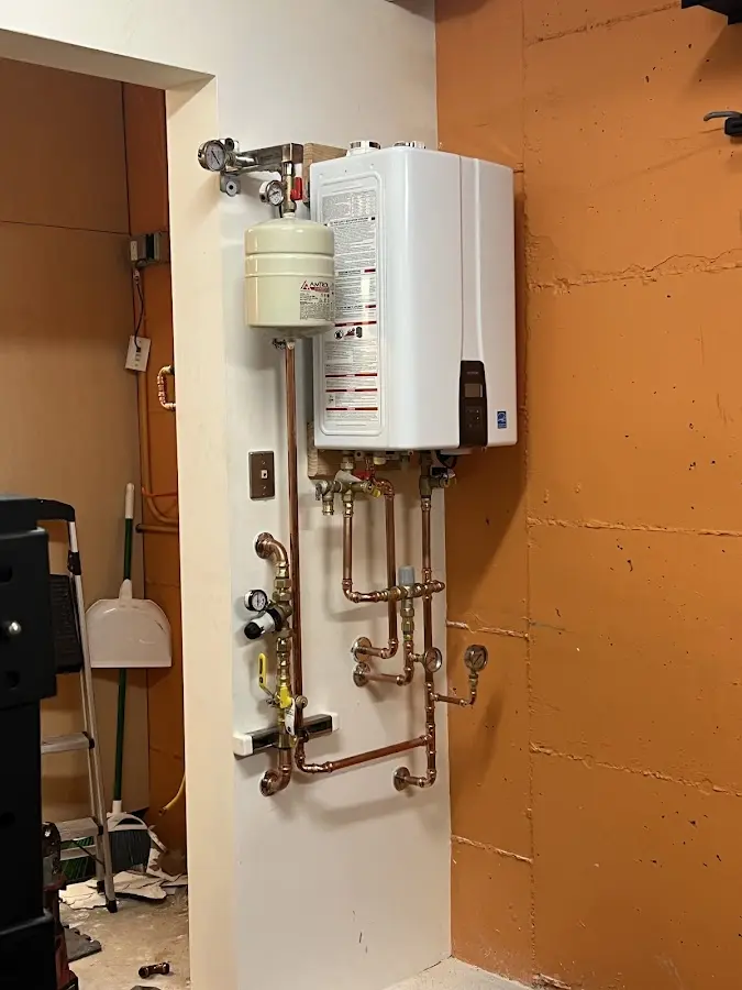 Plumbing technician inspecting water heater connections in Hearne